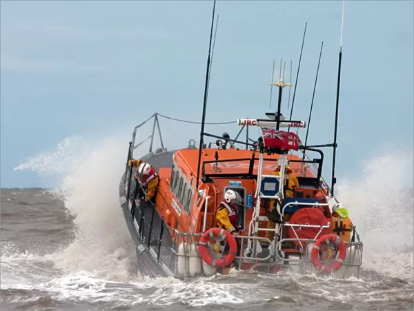 Rhyl Mersey class lifeboat Lil Cunningham 12-24. Lifeboat being launched through breaking wave, crew on baord