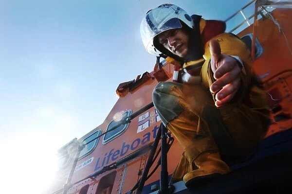 Crew member onboard Portrush Severn class lifeboat William Gordon Burr 17-30 reaching down towards the camera with hand extended
