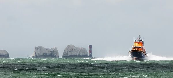 Yarmouth Severn class lifeboat Eric and Susan Hiscock (Wanderer) 17-25 providing safety cover during the Round the Island Race. The Needles lighthouse in the foreground