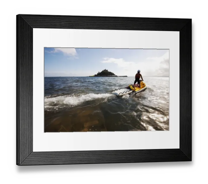 Framed Print : RNLI lifeguard on a rescue watercraft (RWC) with St Michaels Mount near Penzance in the background Framed Print : RNLI lifeguard on a rescue watercraft (RWC) with St Michaels Mount near Penzance in the background
