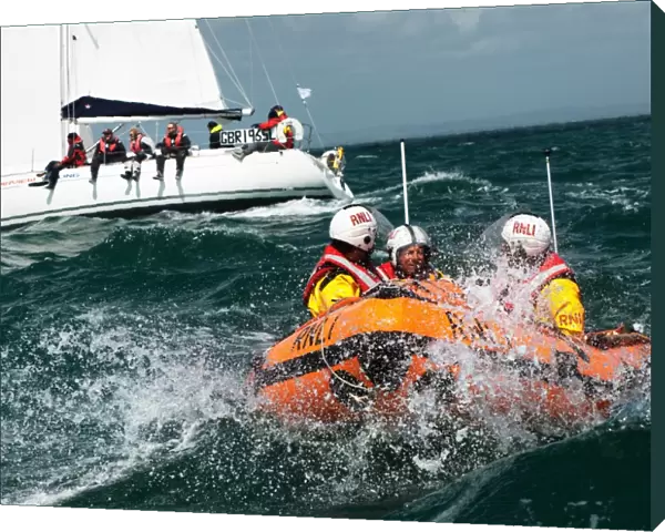 Solent lifeboats provide safety cover during the annual Round the Island Race. Yachts sailing past the Needles. D-class inshore lifeboat pictured