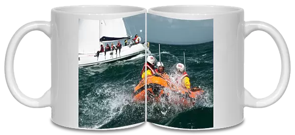 Solent lifeboats provide safety cover during the annual Round the Island Race. Yachts sailing past the Needles. D-class inshore lifeboat pictured