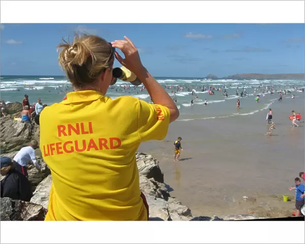 An RNLI lifeguard monitoring the busy Perranporth beach