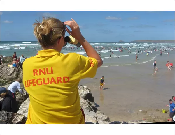 An RNLI lifeguard monitoring the busy Perranporth beach