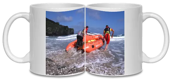 Two RNLI lifeguards launching an Arancia inshore rescue boat