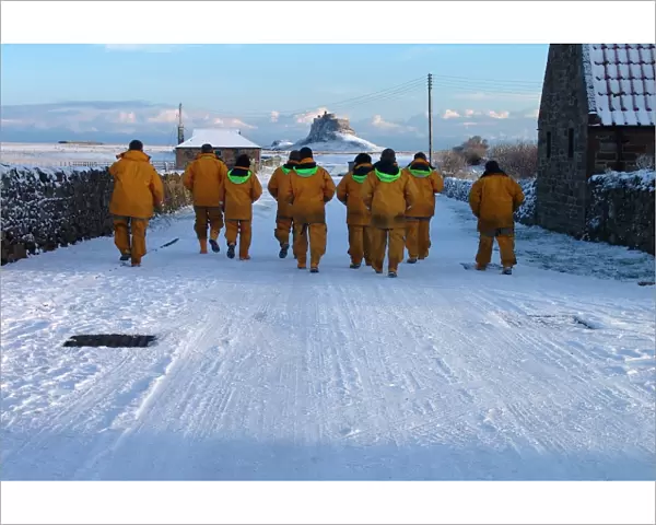 Seahouses crewmembers walk back to their lifeboat in the snow