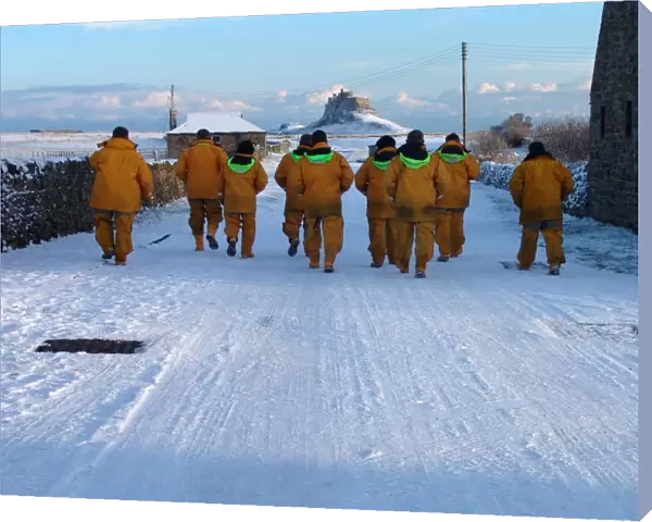 Seahouses crewmembers walk back to their lifeboat in the snow