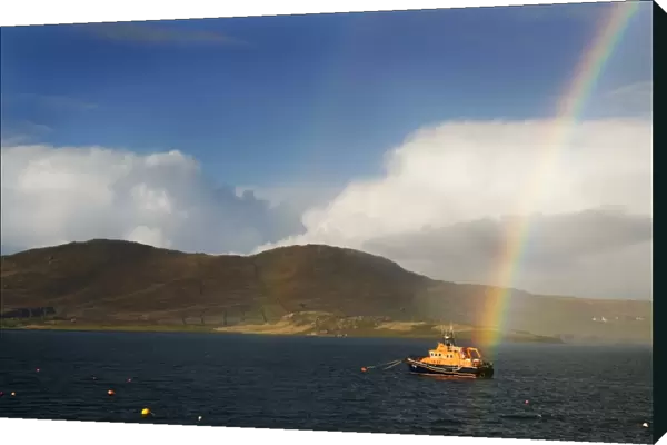 Valentia severn class lifeboat John and Margaret Doig 17-07. Lifeboat is moored in the harbour with a rainbow directly above. and hills in the distance