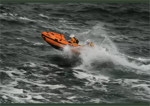 Ballyglass D-class inshore lifeboat The Western D-687. Lifeboat moving from right to left, three crew on board, bow out of the water