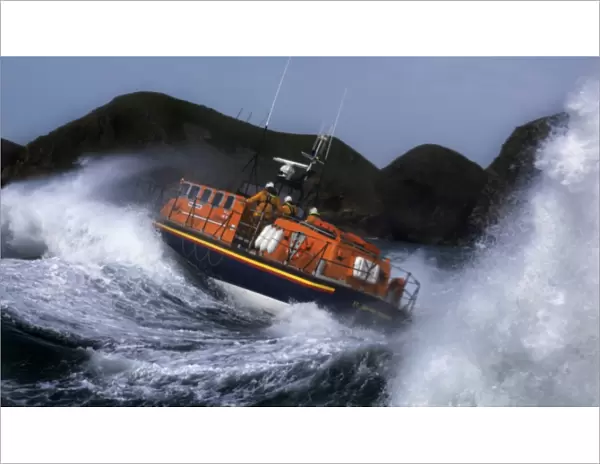 St Davids Tyne class lifeboat Garside 47-026 in rough seas. Three crew can be seen at the upper steering position. Lifeboat is breaking through a large wave and lots of white water