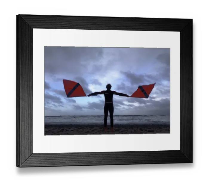 Framed Print : Lifeguard on Cromer beach waving two red flags. Silhouette Framed Print : Lifeguard on Cromer beach waving two red flags. Silhouette