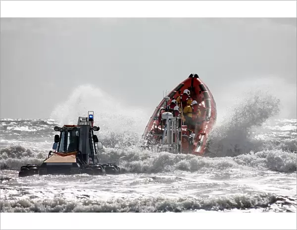 St Bees Atlantic 85 class inshore lifeboat Joy Morris MBE B-831 being launched from a trailer in rough seas. Four crew on board, bow high out of the water