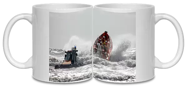 St Bees Atlantic 85 class inshore lifeboat Joy Morris MBE B-831 being launched from a trailer in rough seas. Four crew on board, bow high out of the water