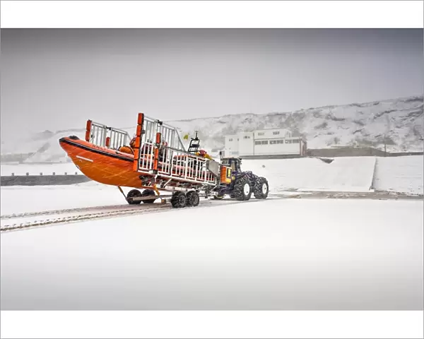 Sheringham Atlantic 85 inshore lifeboat The Oddfellows B-818 on a launching trailer on the beach, snow covering everything and station in the background