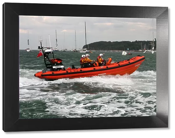 Cowes Atlantic 85 inshore lifeboat Tabbycat B-810 moving from left to right at speed during a demonstration at Cowes Week