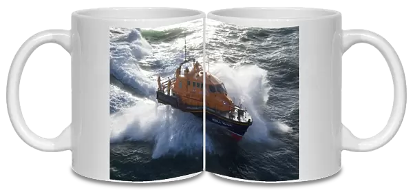 Padstow Tamar class lifeboat Spirit of Padstow 16-04. Lifeboat is heading from left to right in choppy seas, lots of white spray. CAUTION: CHECK USE OF FLAG