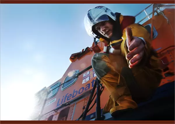 Crew member onboard Portrush Severn class lifeboat William Gordon Burr 17-30 reaching down towards the camera with hand extended