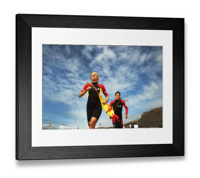 Framed Print : Two lifeguards running along the beach towards the camera, taken from below looking up Framed Print : Two lifeguards running along the beach towards the camera, taken from below looking up