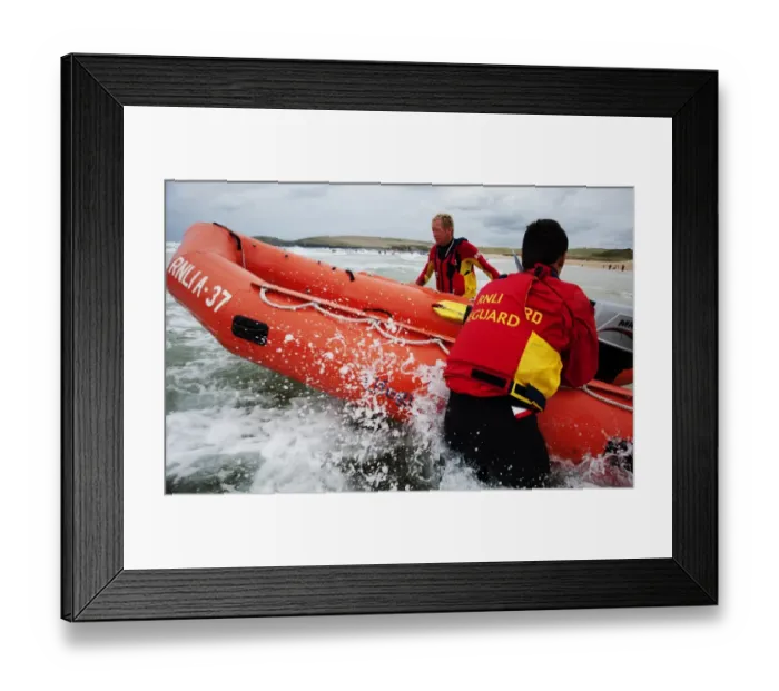 Framed Print : Two lifeguards launching an arancia inshore rescue boat at Constantine Bay, Cornwall Framed Print : Two lifeguards launching an arancia inshore rescue boat at Constantine Bay, Cornwall