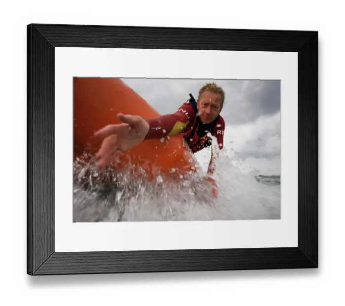 Framed Print : Two lifeguards on an arancia inshore rescue boat at Watergate Bay, Cornwall, heading towards the camera. Lifeguard reaching down towards casualty Framed Print : Two lifeguards on an arancia inshore rescue boat at Watergate Bay, Cornwall, heading towards the camera. Lifeguard reaching down towards casualty
