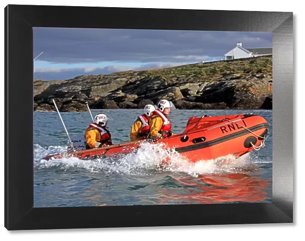Trearddur Bay D-class inshore lifeboat Flo and Dick Smith D-614 during a training exercise. Lifeboat moving from left to right, three crew on board