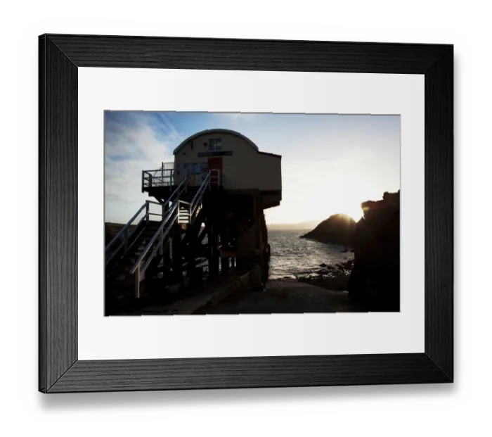 Framed Print : St Davids lifeboat station. Shot from behind the station looking out to sea, sun setting behind rocks in the distance Framed Print : St Davids lifeboat station. Shot from behind the station looking out to sea, sun setting behind rocks in the distance
