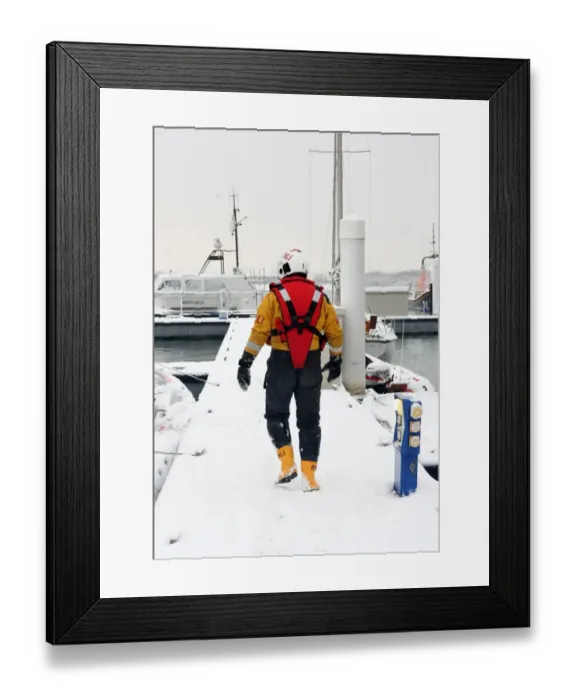 Framed Print : Lifeboat crew member walking along a snow covered pontoon at the Lifeboat College, Poole Framed Print : Lifeboat crew member walking along a snow covered pontoon at the Lifeboat College, Poole