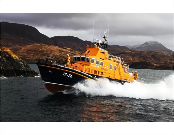 Mallaig severn class lifeboat Henry Alston Hewat 17-26. Lifeboat in the distance moving from right to left, hills and cliffs behind