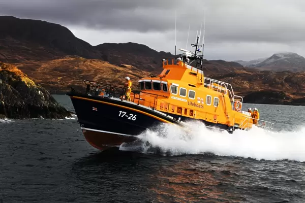 Mallaig severn class lifeboat Henry Alston Hewat 17-26. Lifeboat in the distance moving from right to left, hills and cliffs behind