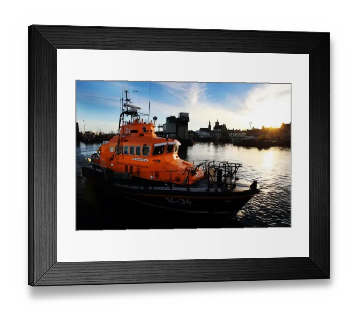 Framed Print : Fraserburgh Trent class lifeboat Willie and Mary Gall 14-34 in the harbour, sun low behind buildings in the background