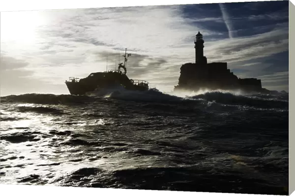 Baltimore Tamar class lifeboat Alan Massey 16-22 silhouetted against sky and Fastnet lighthouse