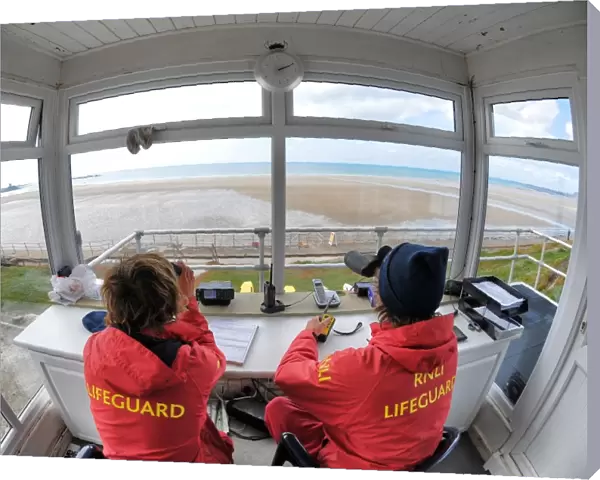Two lifeguards monitoring the sea at a beach in Jersey from lifeguard hut