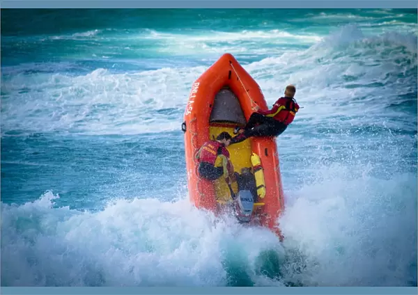 Lifeguards on an arancia inshore rescue boat in the surf at Perranporth beach, Cornwall
