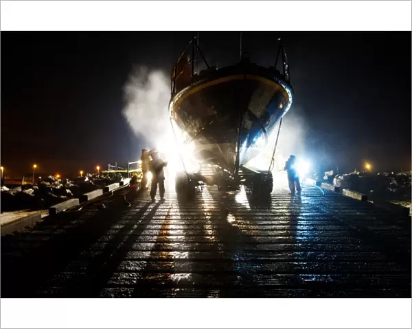 Hoylake mersey class lifeboat Lady of Hilbre 12-005 being washed down by shore crew on the slipway at night. Taken from The Lifeboat: Courage on our Coasts. Page 37