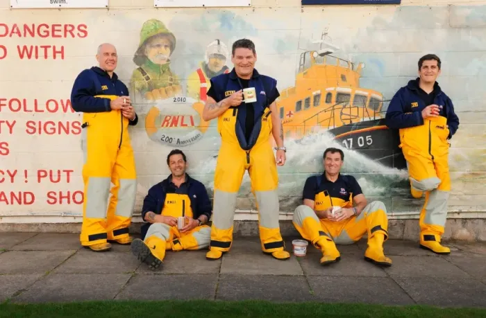 Framed Print : Group shot of Humber crew members lounging against a wall with lifeboat mural on and drinking cups of tea Framed Print : Group shot of Humber crew members lounging against a wall with lifeboat mural on and drinking cups of tea