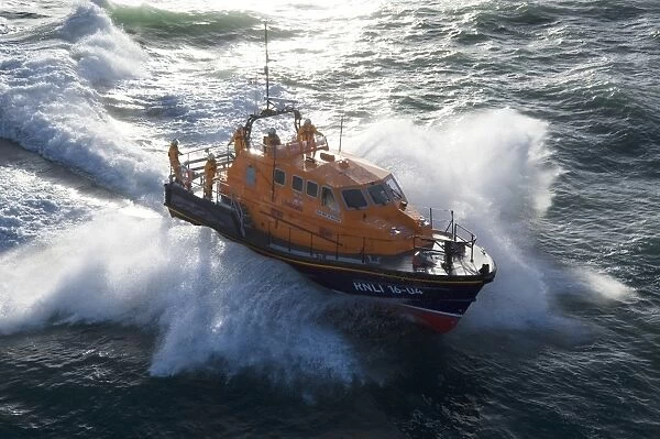 Padstow Tamar class lifeboat Spirit of Padstow 16-04. Lifeboat is heading from left to right in choppy seas, lots of white spray. CAUTION: CHECK USE OF FLAG