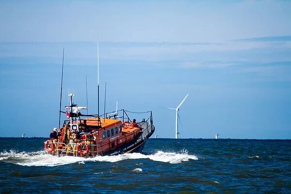 Rhyl Mersey class lifeboat Lil Cunningham 12-24 heading out to sea, windfarms in the distance