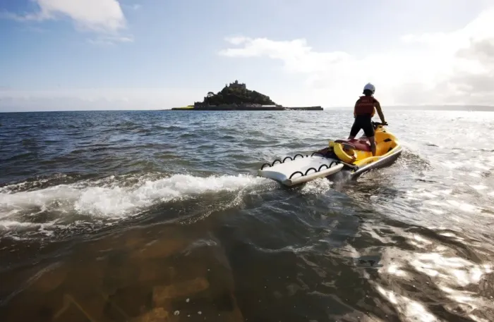 Framed Print : RNLI lifeguard on a rescue watercraft (RWC) with St Michaels Mount near Penzance in the background Framed Print : RNLI lifeguard on a rescue watercraft (RWC) with St Michaels Mount near Penzance in the background