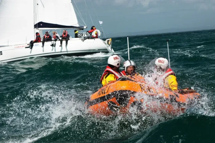 Framed Print : Solent lifeboats provide safety cover during the annual Round the Island Race. Yachts sailing past the Needles. D-class inshore lifeboat pictured Framed Print : Solent lifeboats provide safety cover during the annual Round the Island Race. Yachts sailing past the Needles. D-class inshore lifeboat pictured