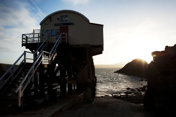 Framed Print : St Davids lifeboat station. Shot from behind the station looking out to sea, sun setting behind rocks in the distance Framed Print : St Davids lifeboat station. Shot from behind the station looking out to sea, sun setting behind rocks in the distance