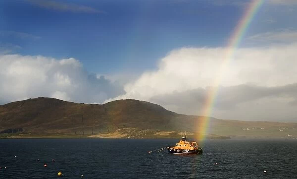 Valentia severn class lifeboat John and Margaret Doig 17-07. Lifeboat is moored in the harbour with a rainbow directly above. and hills in the distance