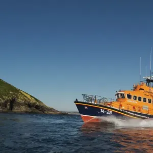 Ballycotton Trent Class lifeboat Austin Lidbury 14-25 moving from right to left, lighthouse in the background. Bright sunny day, blue sky Ballycotton Trent Class lifeboat Austin Lidbury 14-25 moving from right to left, lighthouse in the background. Bright sunny day, blue sky
