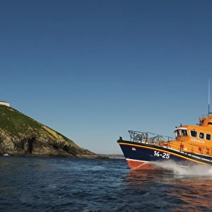 Ballycotton Trent Class lifeboat Austin Lidbury 14-25 moving from right to left, lighthouse in the background. Bright sunny day, blue sky