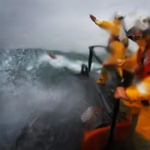 Crew on board relief Tamar class lifeboat Victor Freeman 16-13 wearing new lifejackets. Three crew on the bow of the lifeboat undertaking a search exercise