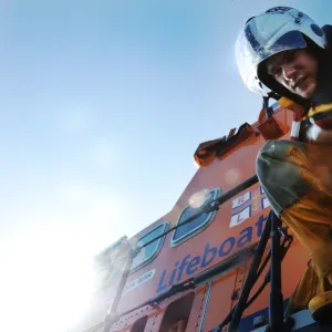 Crew member onboard Portrush Severn class lifeboat William Gordon Burr 17-30 reaching down towards the camera with hand extended