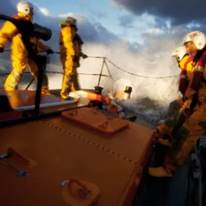 Crew members stood at the bow of the Berwick-upon-Tweed Mersey class lifeboat Joy and Charles Beeby 12-32, lots of spray