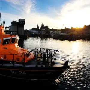 Fraserburgh Trent class lifeboat Willie and Mary Gall 14-34 in the harbour, sun low behind buildings in the background Fraserburgh Trent class lifeboat Willie and Mary Gall 14-34 in the harbour, sun low behind buildings in the background