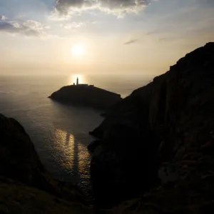 Landscape shot of sun setting behind lighthouse near Beaumaris