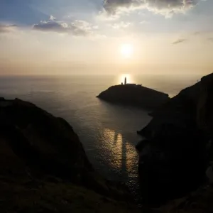Landscape shot of sun setting behind lighthouse near Beaumaris Landscape shot of sun setting behind lighthouse near Beaumaris