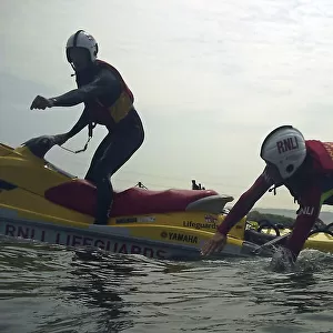 Lifeguard jumping from a rescue watercraft